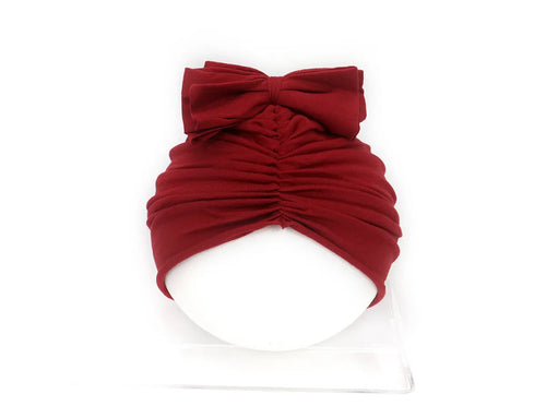 Soft acrylic knitted bonnet for a baby girl, shown in a solid colour, suitable for 0-28 month olds.