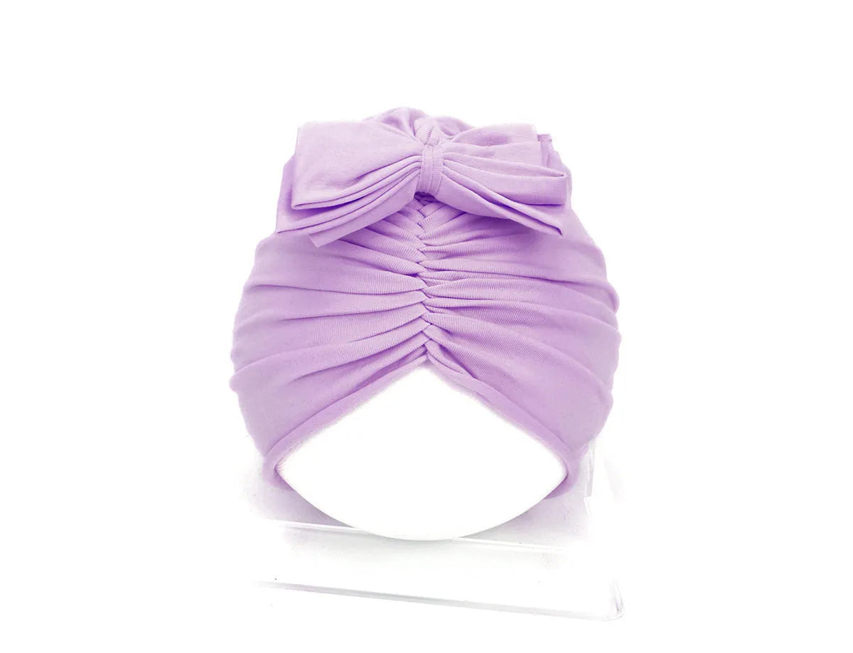 Soft acrylic knitted bonnet for a baby girl, shown in a solid colour, suitable for 0-28 month olds.