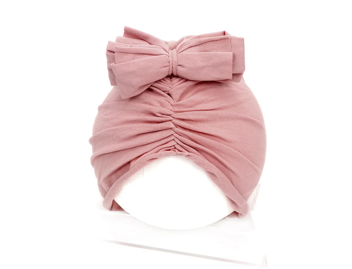 Soft acrylic knitted bonnet for a baby girl, shown in a solid colour, suitable for 0-28 month olds.