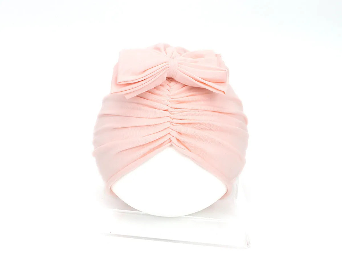 Soft acrylic knitted bonnet for a baby girl, shown in a solid colour, suitable for 0-28 month olds.