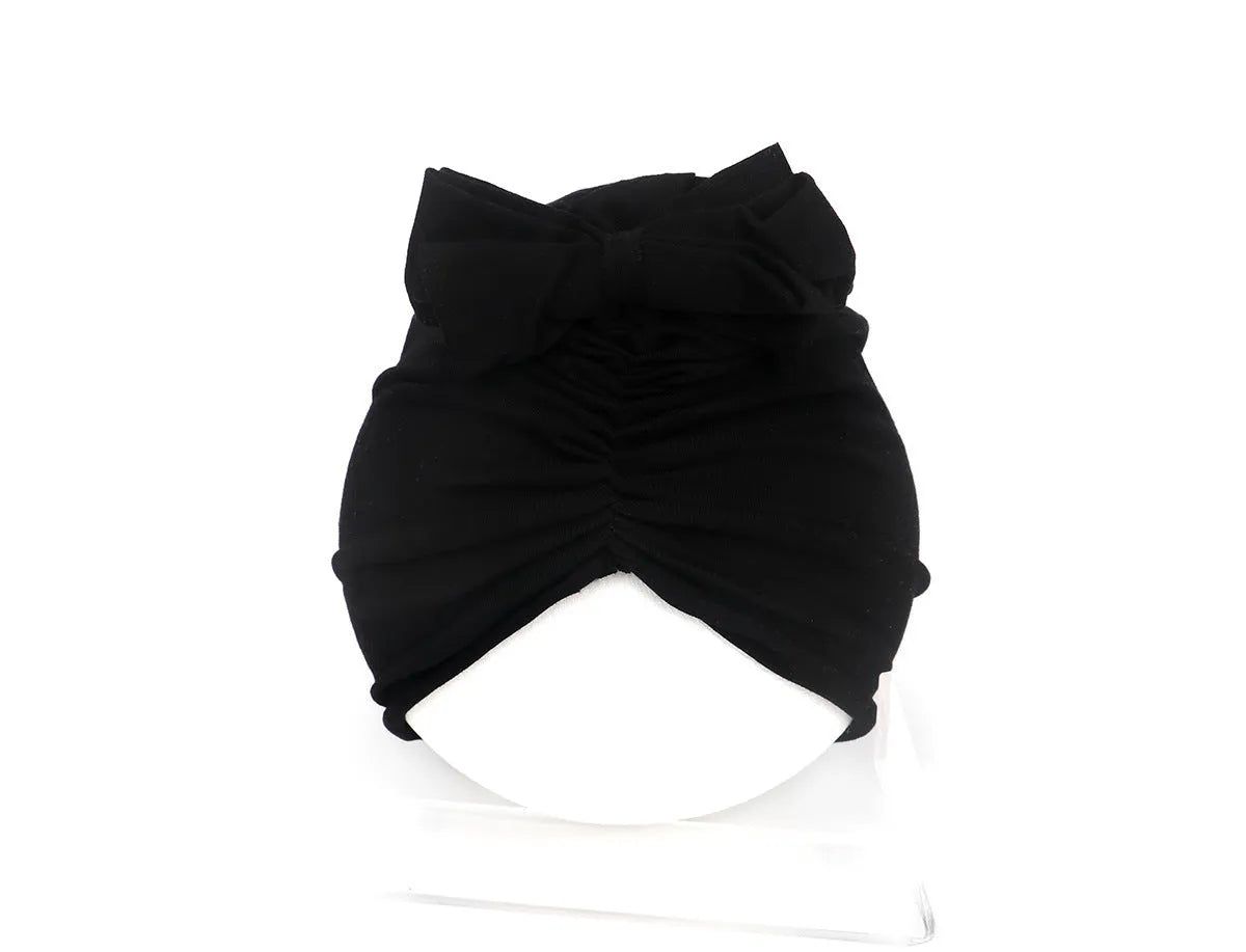 Soft acrylic knitted bonnet for a baby girl, shown in a solid colour, suitable for 0-28 month olds.