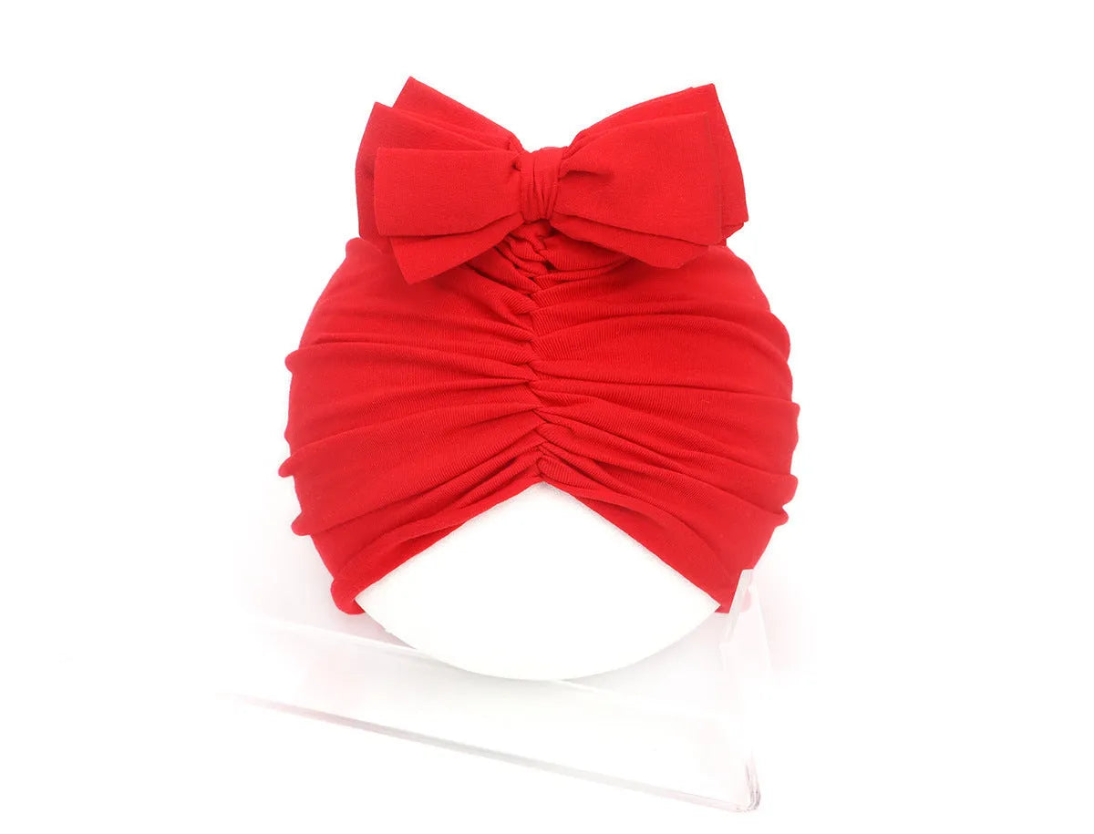 Soft knitted acrylic baby turban hat for newborns to toddlers in a solid pink colour.