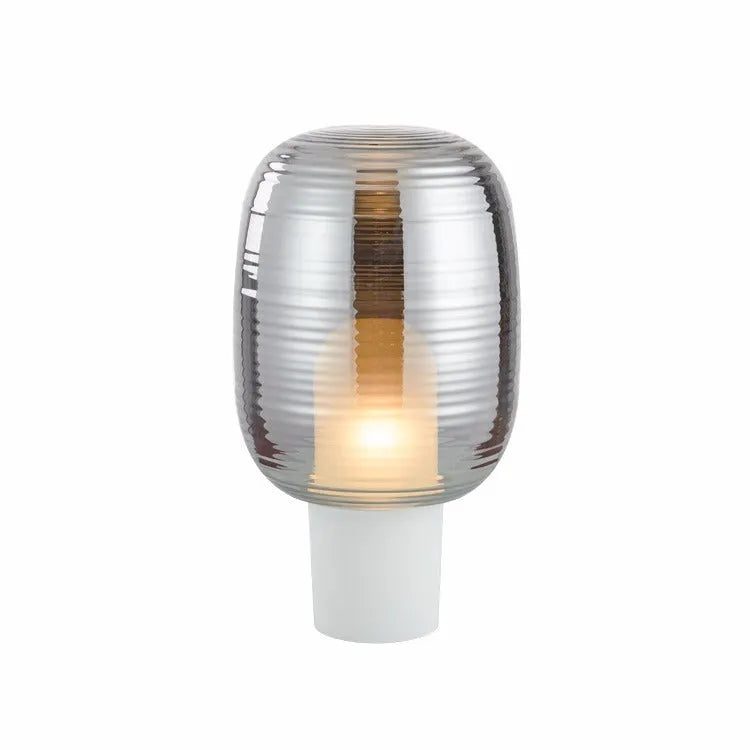 Modern Nordic-style glass table lamp with a choice of Cognac or Smoky grey shade on a wooden surface.