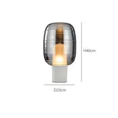 Modern Nordic-style glass table lamp with a choice of Cognac or Smoky grey shade on a wooden surface.