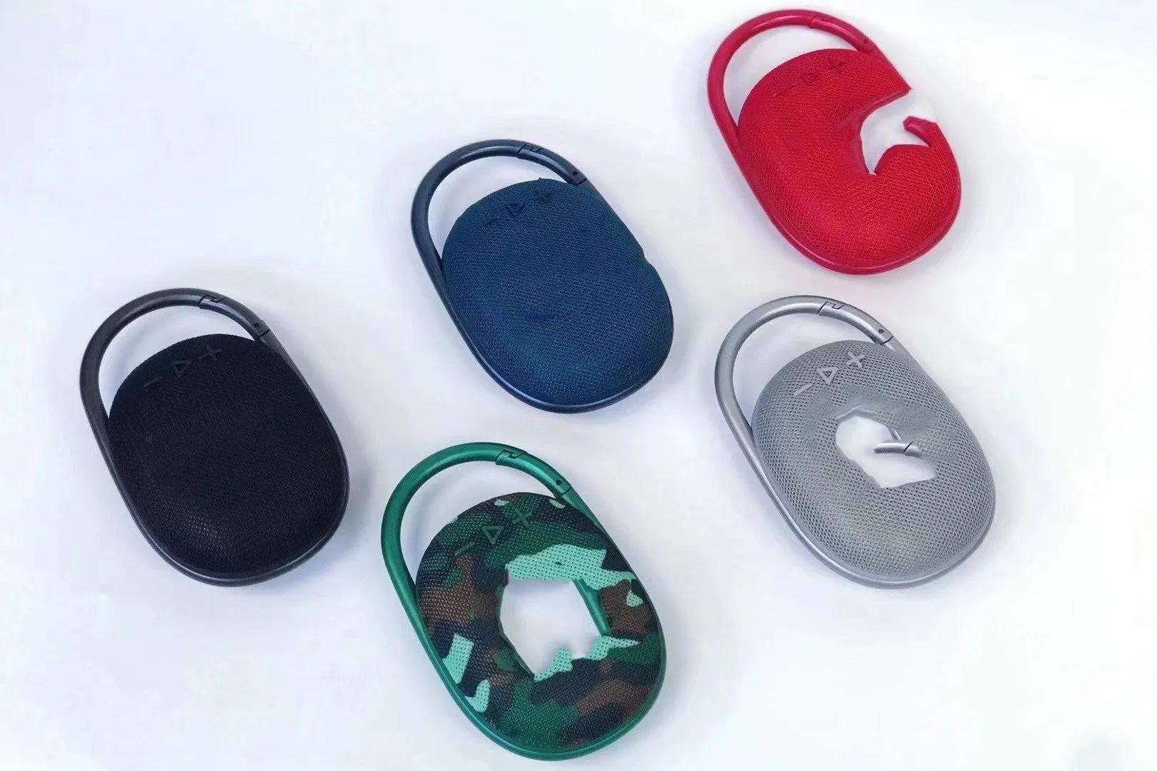 A small portable Bluetooth speaker in one of six colours: black, blue, green, pink, red, or silver grey.