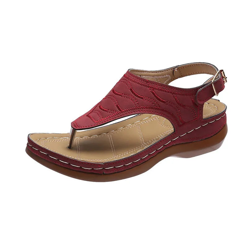 Women's red wedge heel flip flop sandals with an adjustable buckle strap on a plain background.