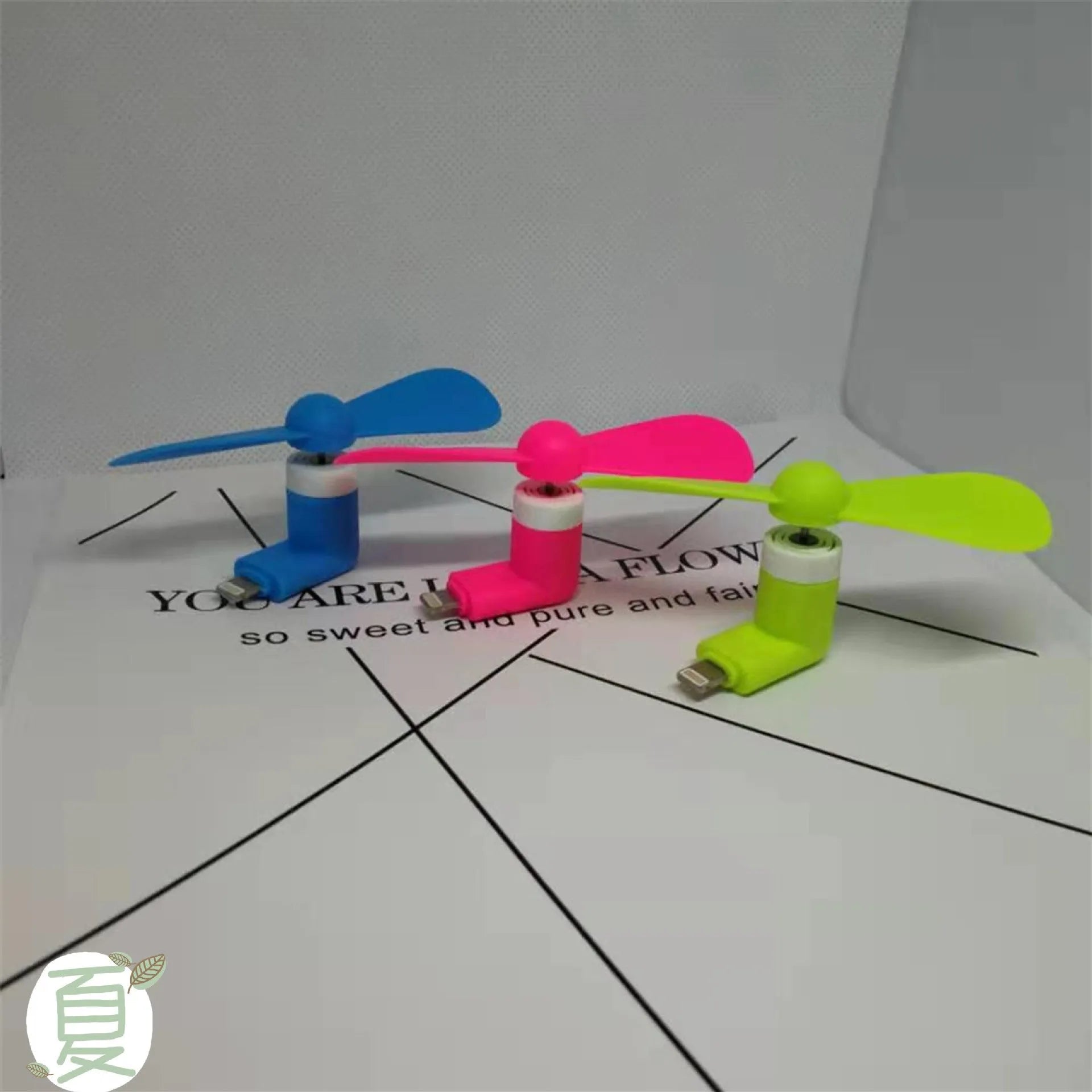 Portable mobile phone mini fan with plastic blades and rotary switch in multiple colours.