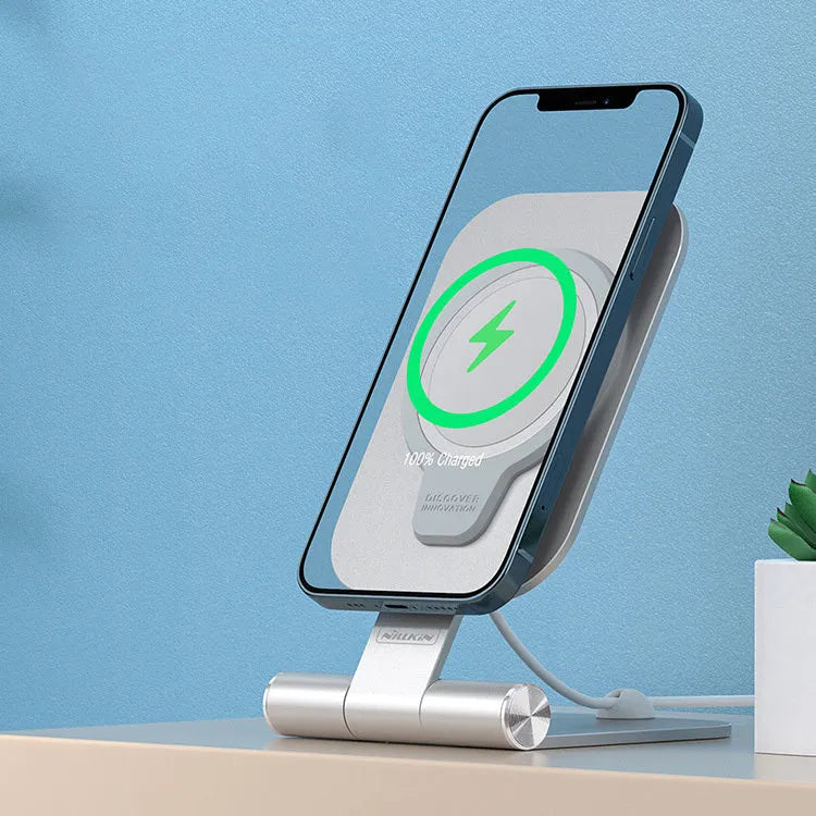 NILLKIN silver foldable aluminium alloy magnetic wireless charging stand for iPhone 12 Mini and 12 Pro Max on a desk