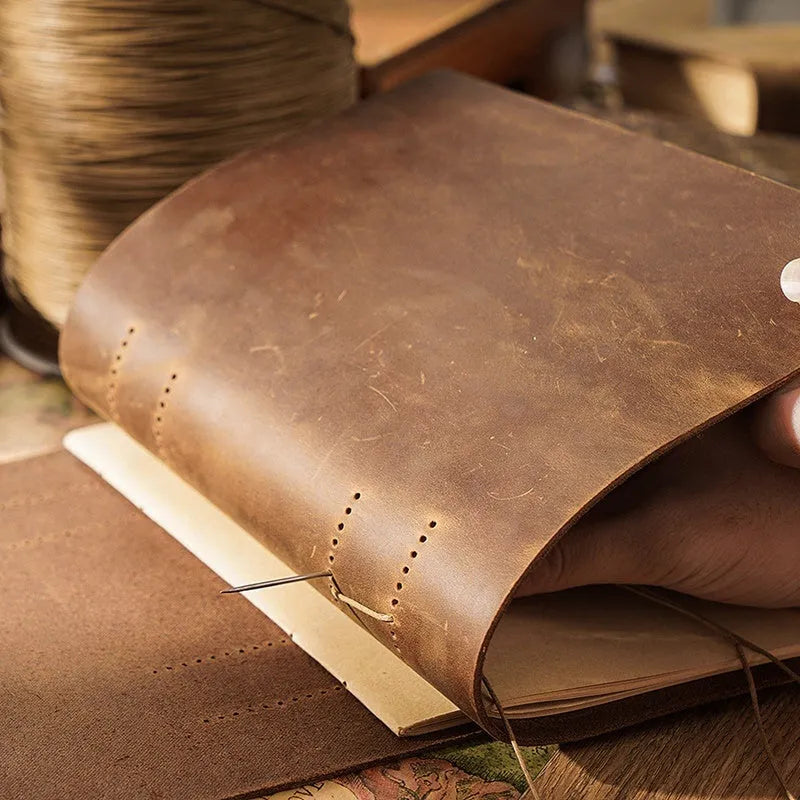 Handmade leather notebook with brown Crazy Horse cover, 200 pages, 19x14cm, open on a desk