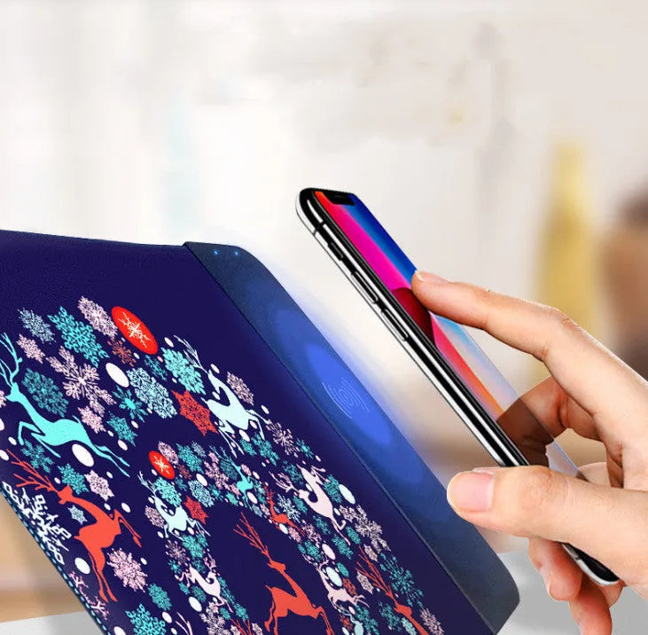 Black wireless charging mouse pad with cartoon design, showing RGB lighting and USB cable.