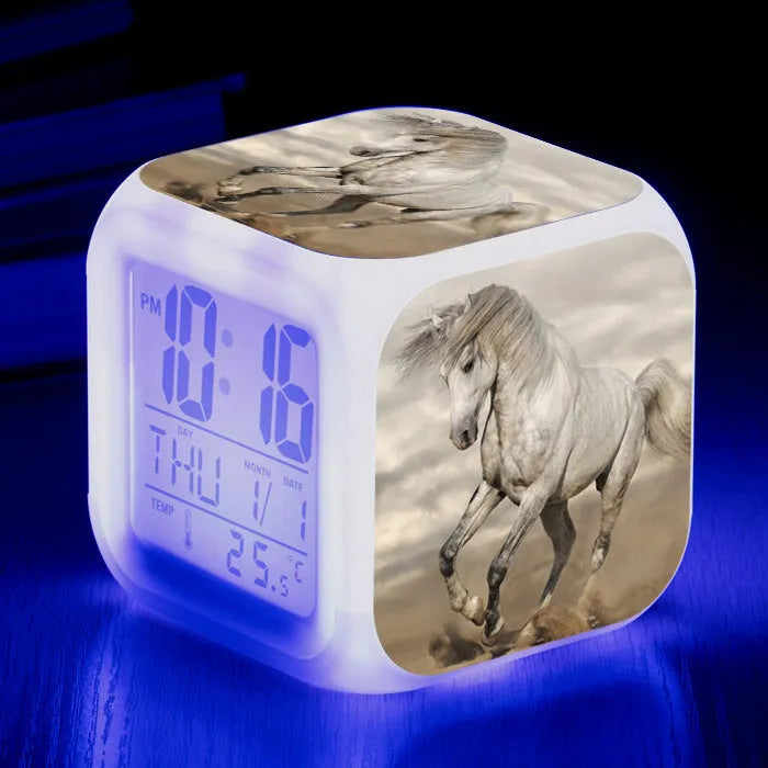 Small square cartoon-style LED alarm clock showing digital time and temperature on a colourful display.
