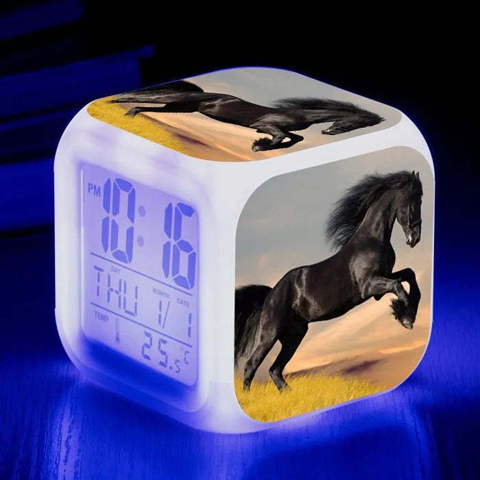Small square cartoon-style LED alarm clock showing digital time and temperature on a colourful display.