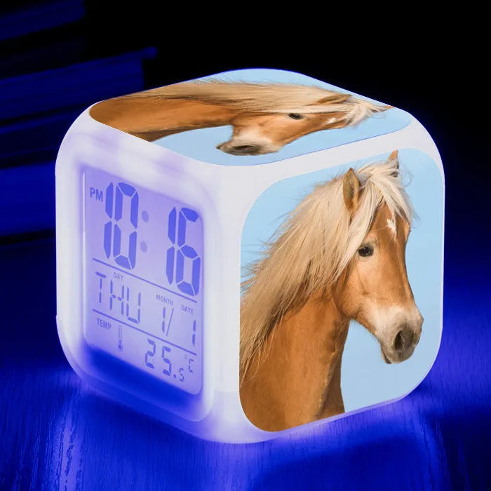 Small square cartoon-style LED alarm clock showing digital time and temperature on a colourful display.