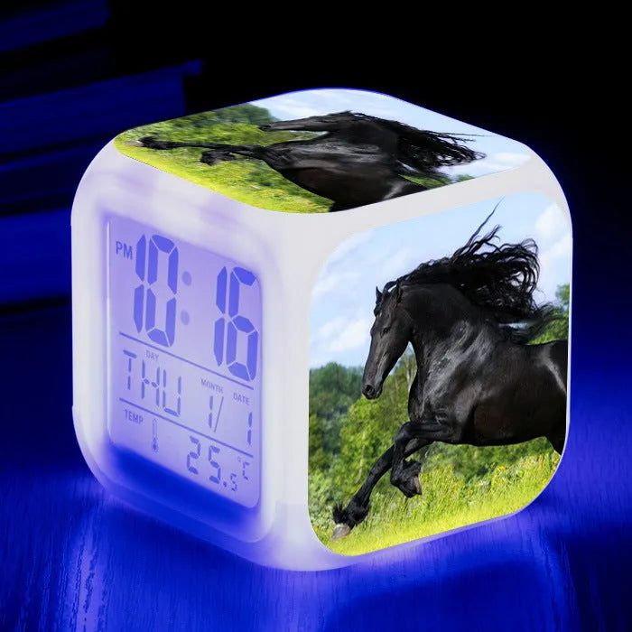Small square cartoon-style LED alarm clock showing digital time and temperature on a colourful display.
