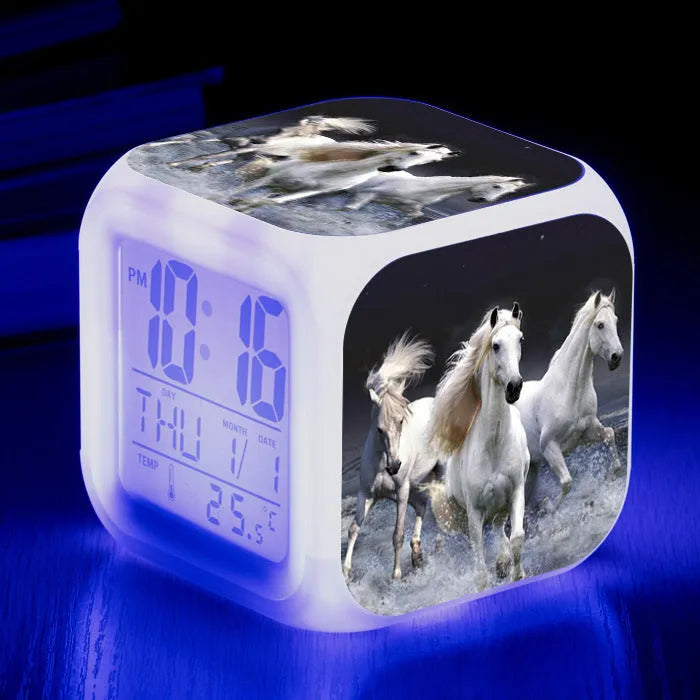 Small square cartoon-style LED alarm clock showing digital time and temperature on a colourful display.