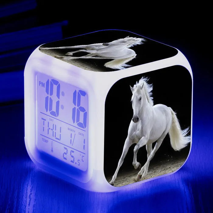 Small square cartoon-style LED alarm clock showing digital time and temperature on a colourful display.