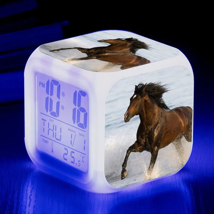 Small square cartoon-style LED alarm clock showing digital time and temperature on a colourful display.
