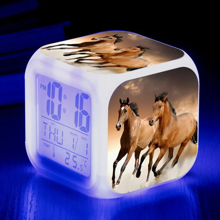Small square cartoon-style LED alarm clock showing digital time and temperature on a colourful display.