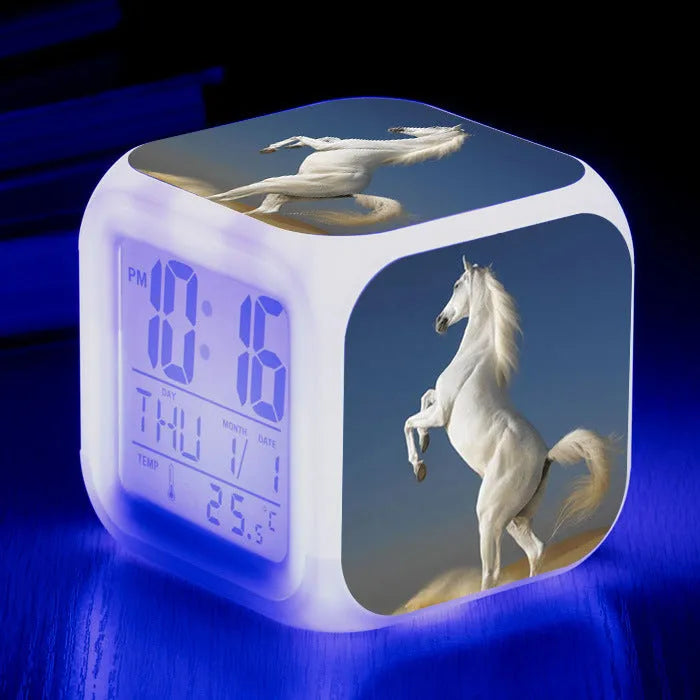 Small square cartoon-style LED alarm clock showing digital time and temperature on a colourful display.