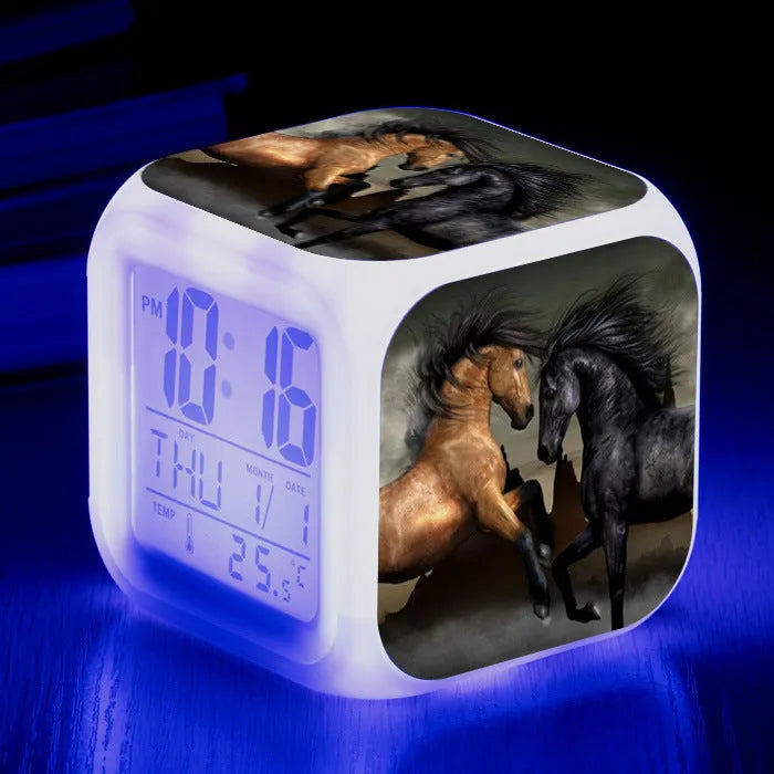 Small square cartoon-style LED alarm clock showing digital time and temperature on a colourful display.