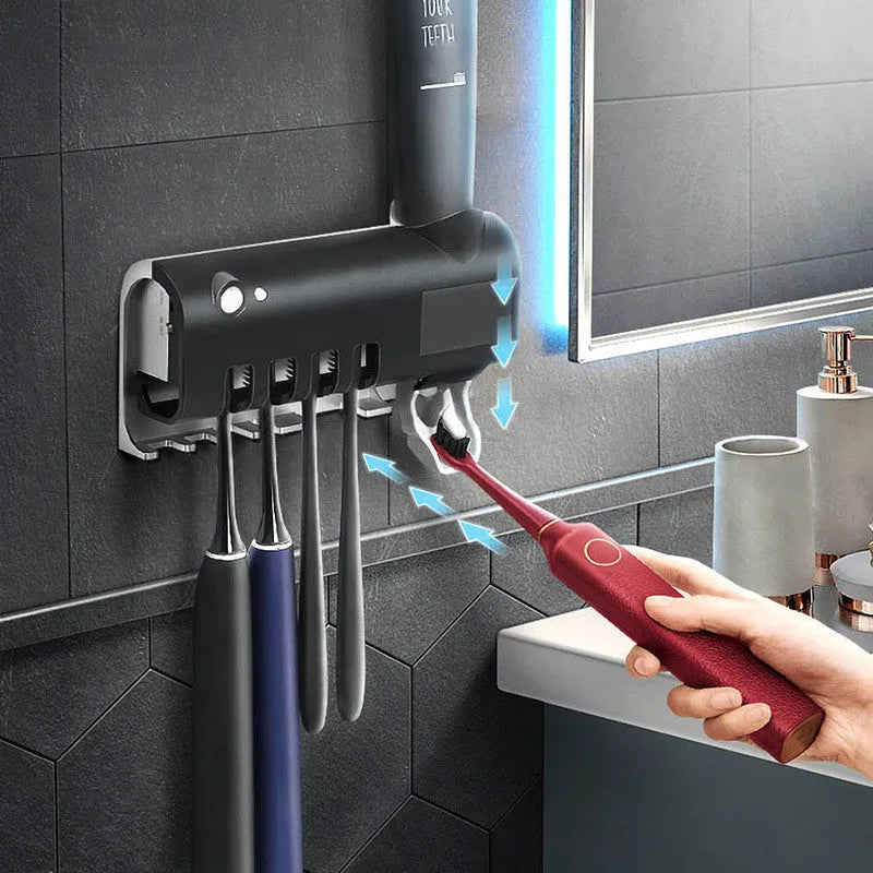 Black wall-mounted toothbrush steriliser with UV light and integrated toothpaste squeezer.