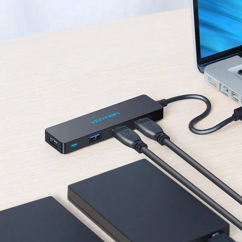 Black USB 3.0 hub with 4 ports and 15cm shielded cable connecting to computer