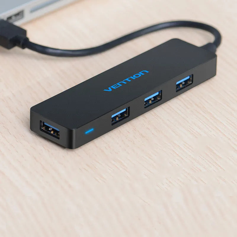 Black USB 3.0 hub with 4 ports and 15cm shielded cable connecting to computer