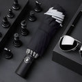 Black automatic reverse folding car umbrella showing inverted closure mechanism and plastic non-slip handle.