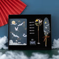 Chinese style feather pen set with metal sheaths in four colours alongside a Jianhegui notebook.