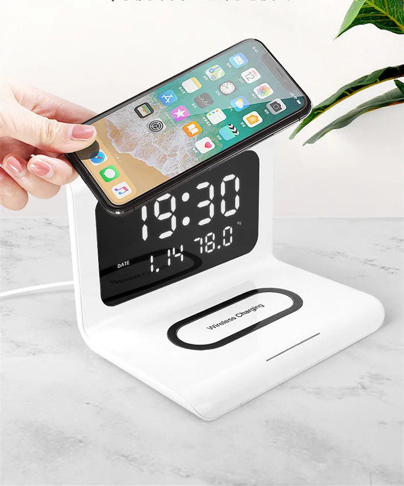 White wireless charging alarm clock showing time, date and temperature on bedside table