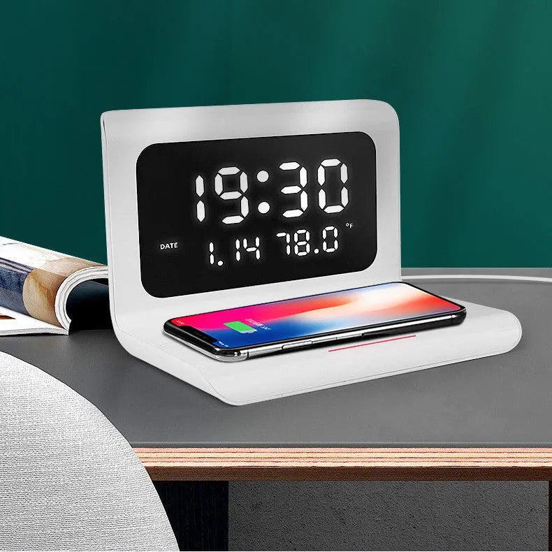 White wireless charging alarm clock showing time, date and temperature on bedside table