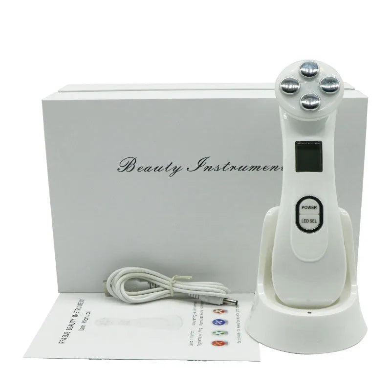 White multi-functional facial beauty instrument with LED colour light, acne needle, blackhead suction and shoveling machine attachments on table