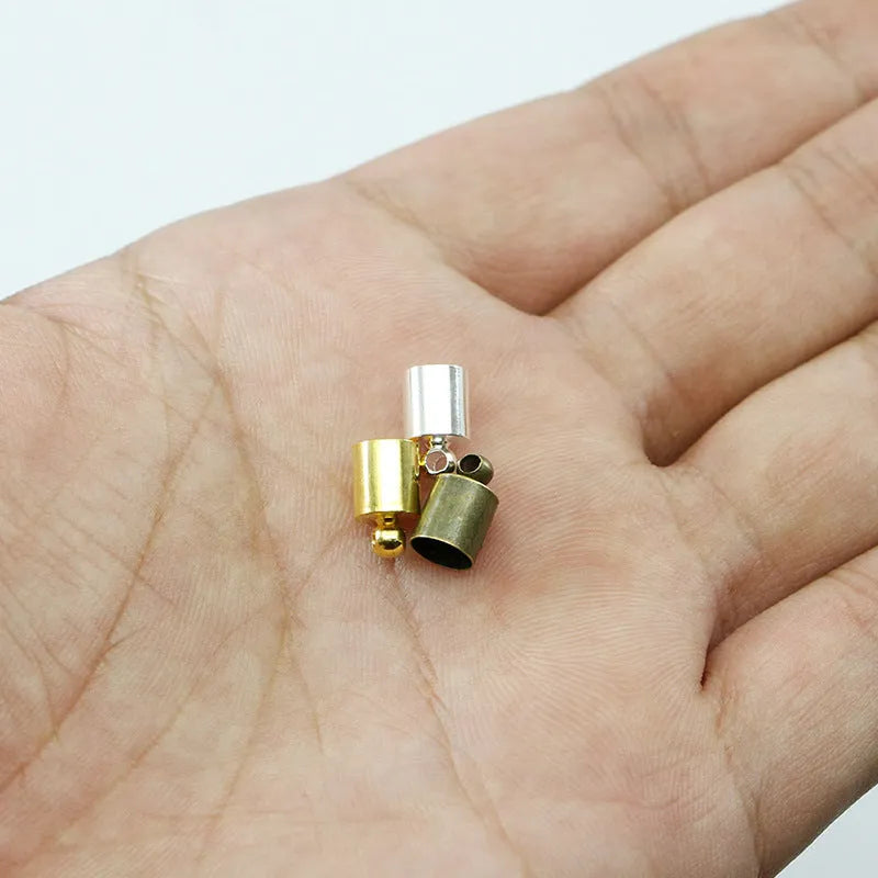 Assortment of small copper pendant weight caps in gold, silver, bronze, and black electroplated finishes.