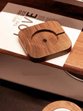 Walnut wood magnetic wireless charger bracket holding phone upright on desktop