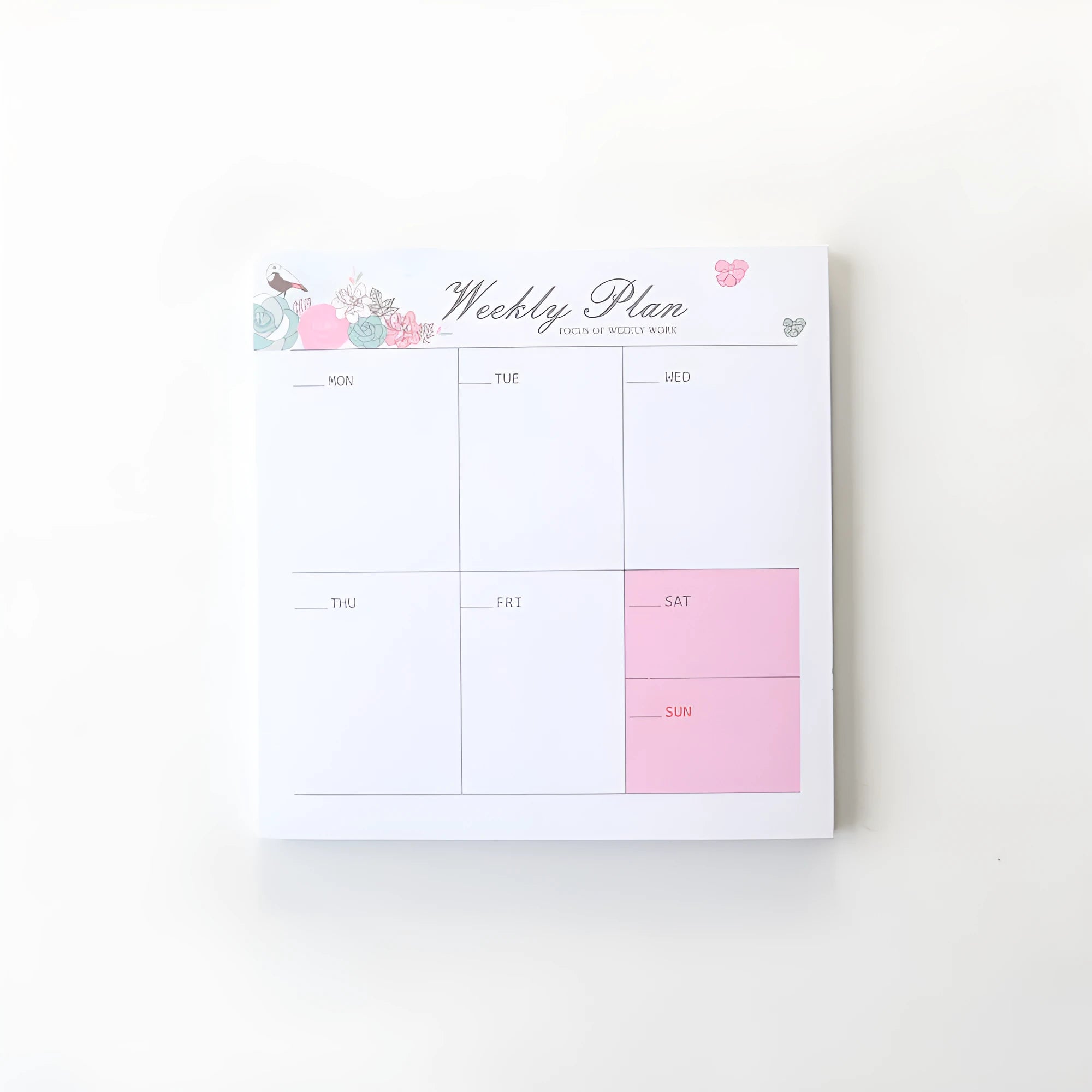Student desk organiser pad notebook with pink and green cover, open to show A4 monthly and A5 weekly planning inserts.