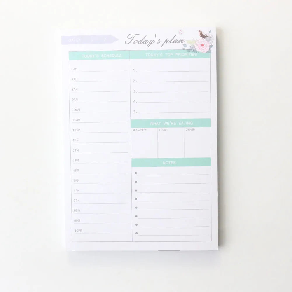 Student desk organiser pad notebook with pink and green cover, open to show A4 monthly and A5 weekly planning inserts.