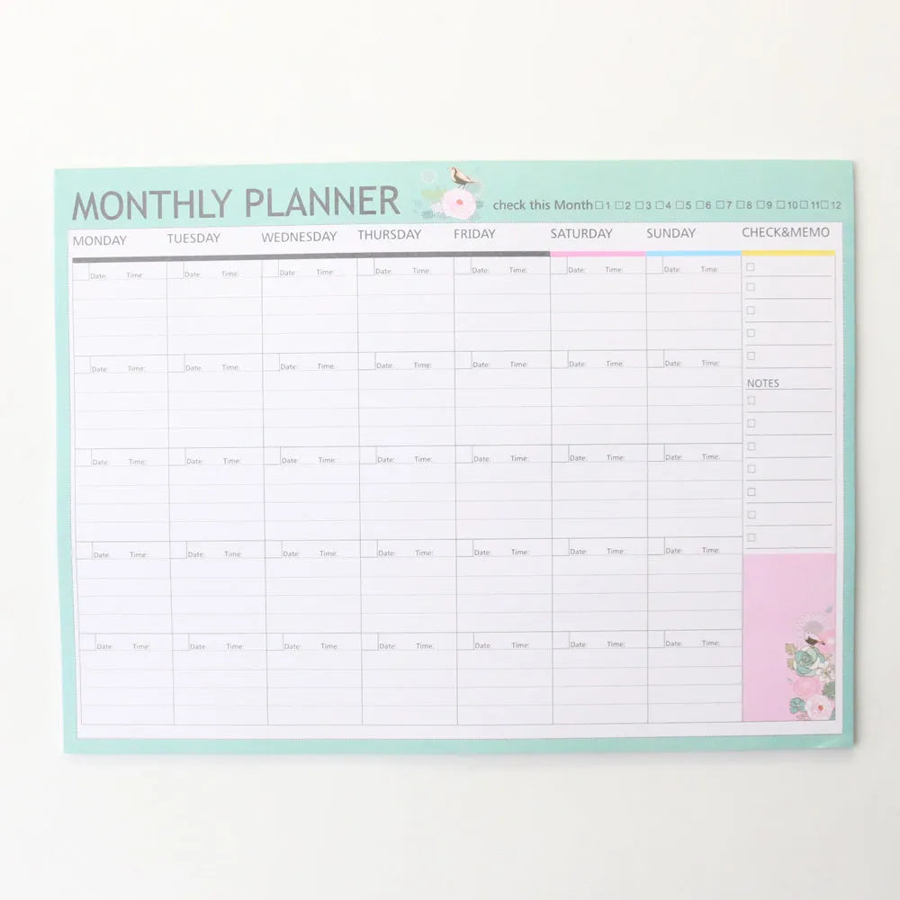 Student desk organiser pad notebook with pink and green cover, open to show A4 monthly and A5 weekly planning inserts.