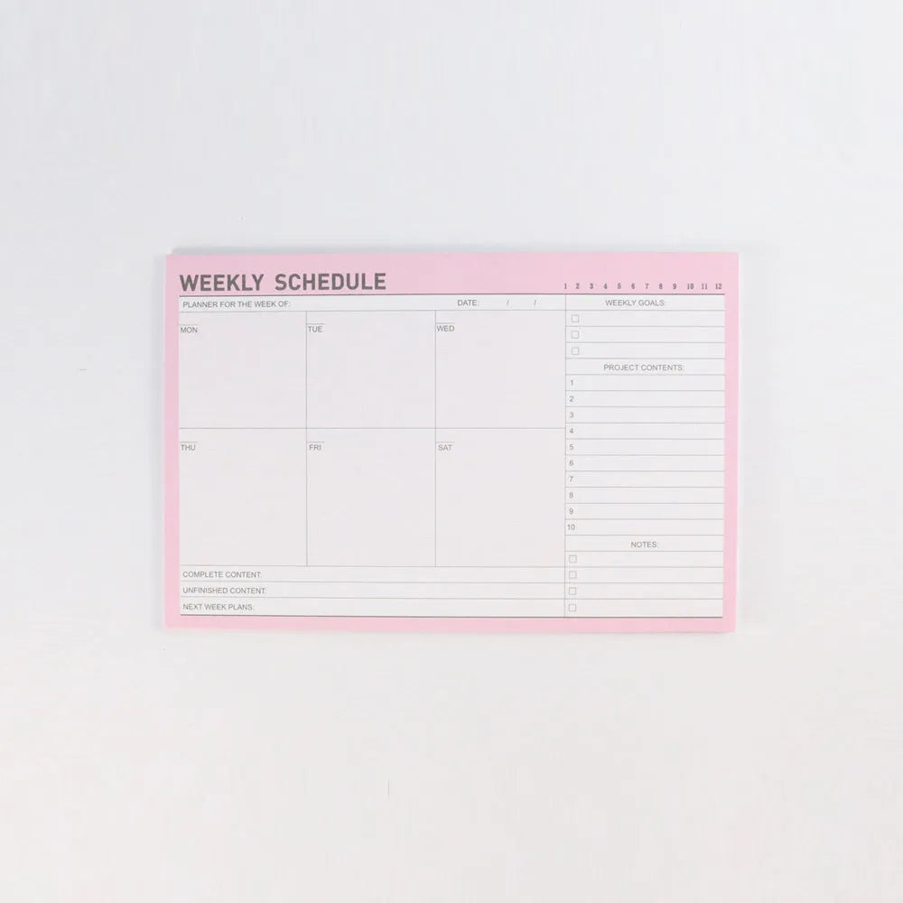 Student desk organiser pad notebook with pink and green cover, open to show A4 monthly and A5 weekly planning inserts.
