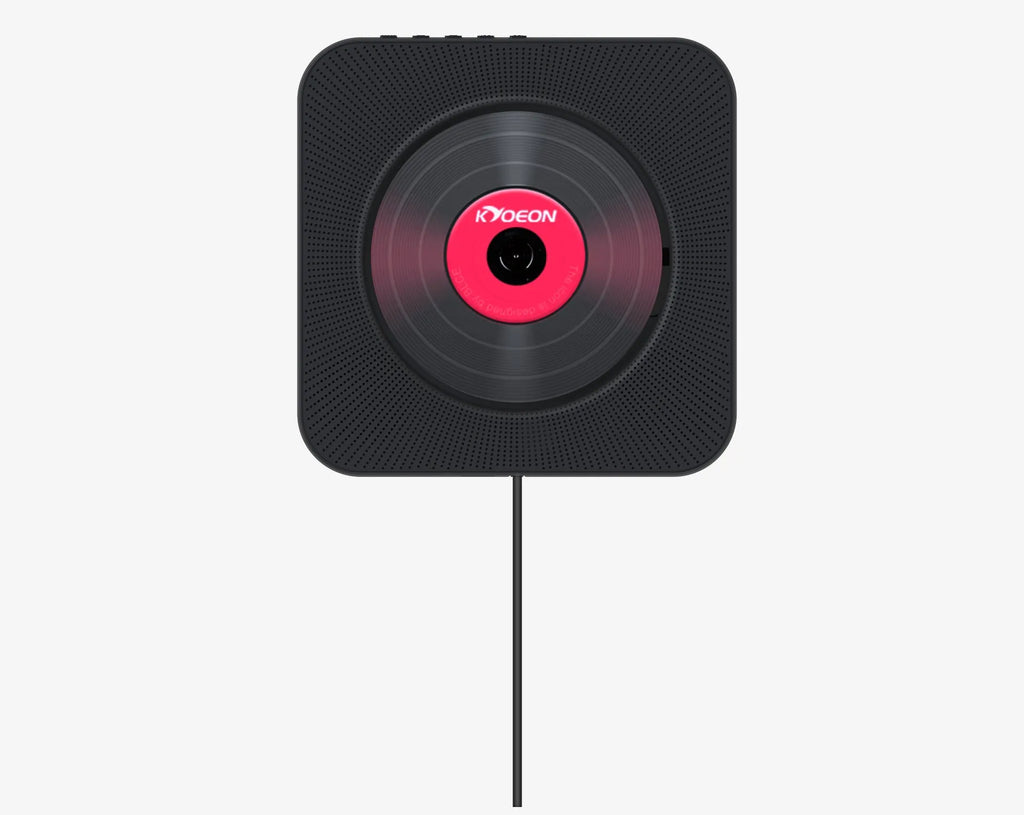 Wall-mounted white CD and DVD player with a digital display and remote control on a table.