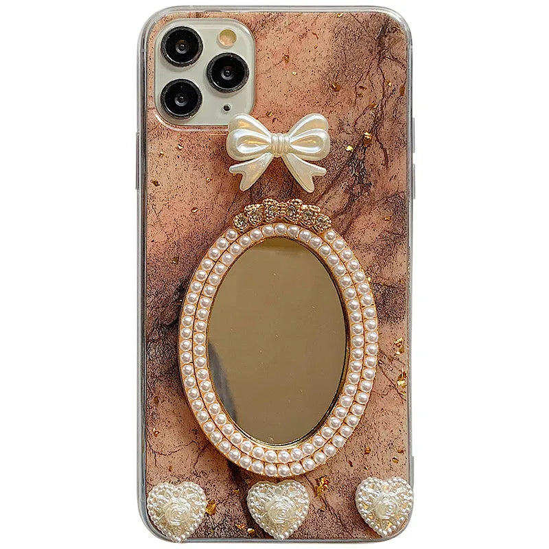 Brown marble silicone iPhone case with a rhinestone bowknot and a small circular mirror on the back.