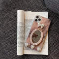 Brown marble silicone iPhone case with a rhinestone bowknot and mirror detail.