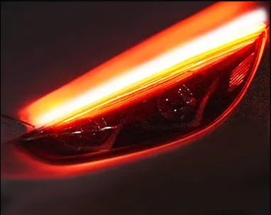 Slim silicone car LED daytime running light strip with flowing turn signal effect on a vehicle headlight.