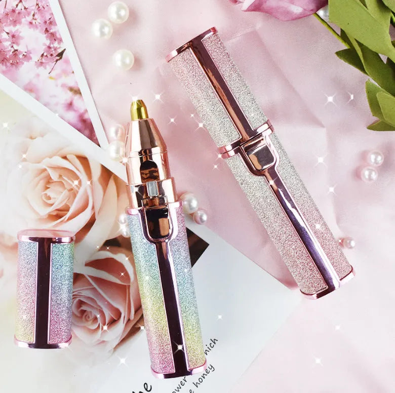 Lipstick shape electric eyebrow trimmer with gold plated head in Rainbow or Starry Sky colour, 2.5 x 2.5 x 12.5 cm.