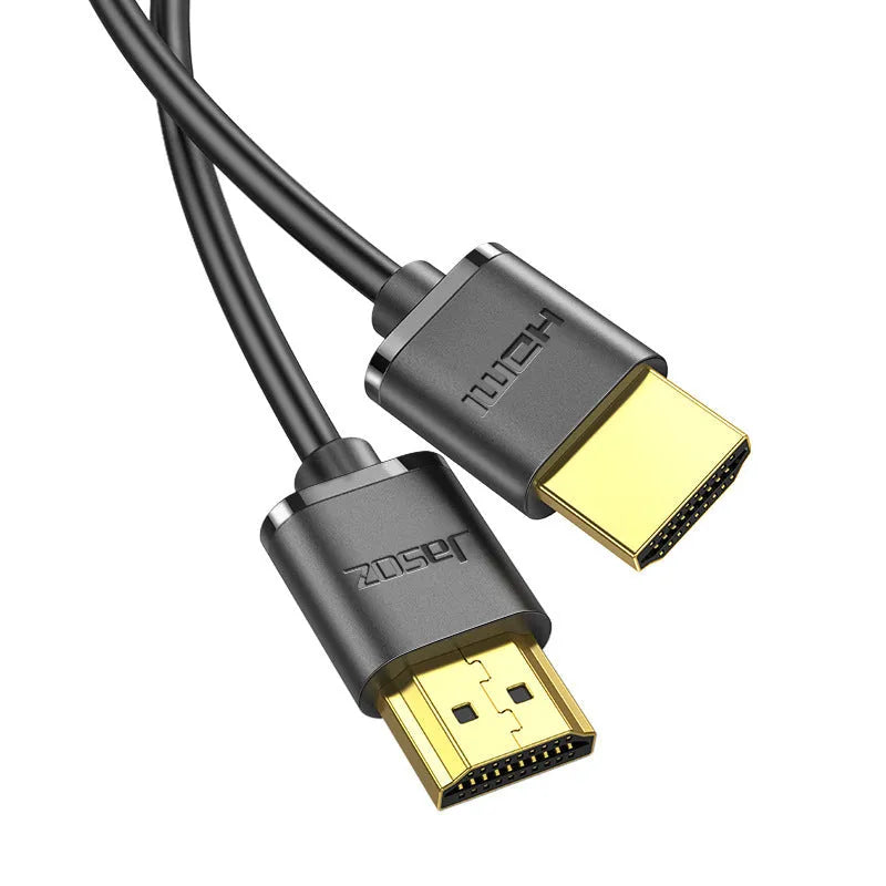 Close-up of a black HDMI cable with gold-plated connectors and a flexible cord on a grey background.