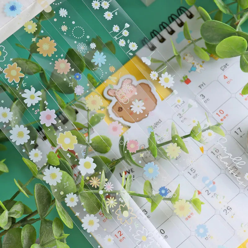 Five rolls of transparent decorative adhesive tape with Midsummer Daisy pattern, showing 1.5cm width