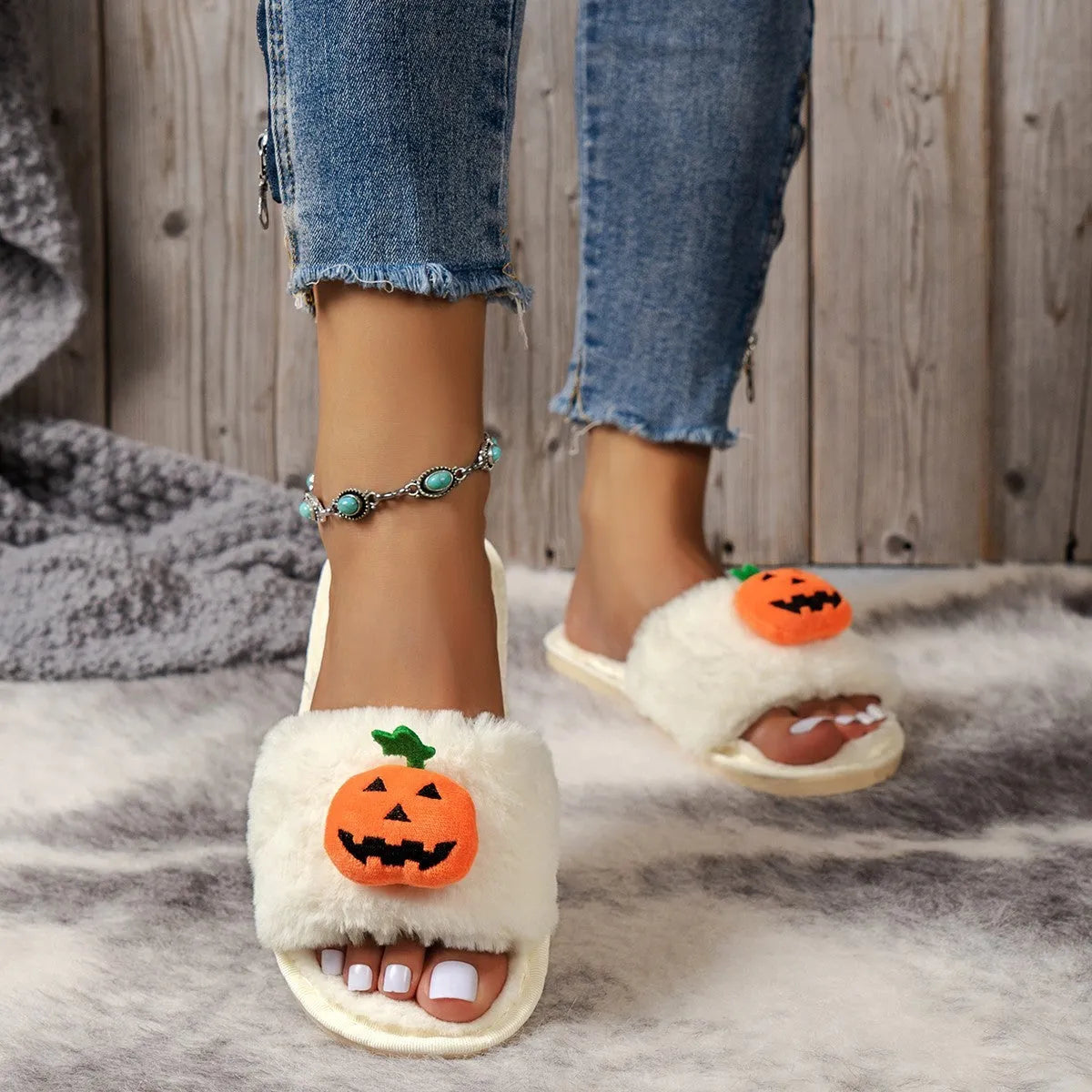 Yellow cartoon pumpkin plush slippers with open toe and anti-slip sole on a white background.