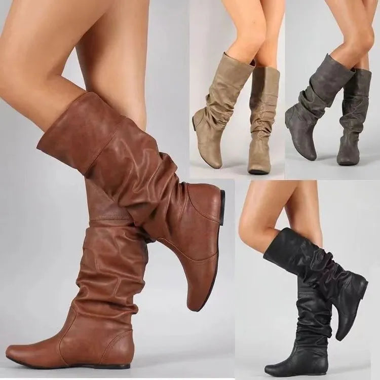 Women's flat ankle boots in black with round toe, high cylinder shaft, slip-on design and rubber sole.