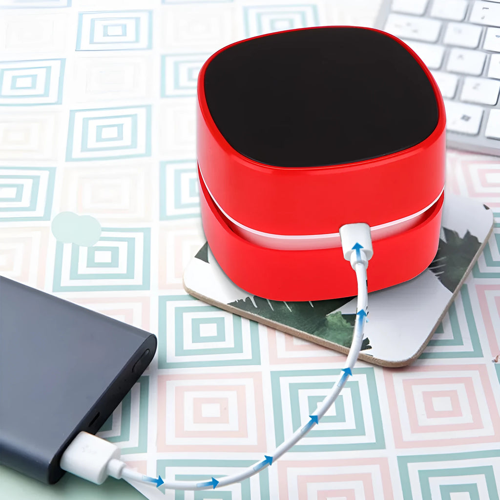 Desktop vacuum cleaner in blue with two-in-one brush nozzle on a desk