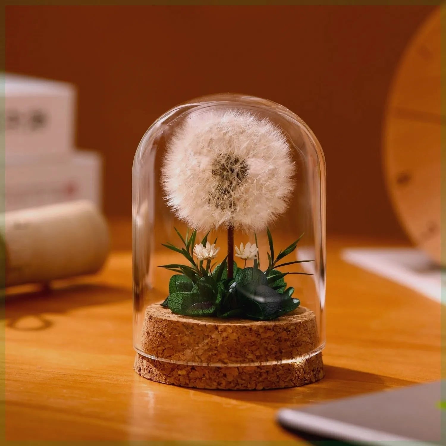Dandelion-shaped glass night light ornament in gradient colours on wooden surface