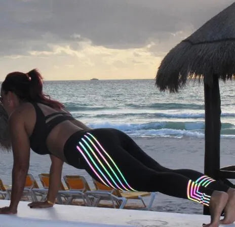 Women's black workout leggings with glowing print design and slim fit pencil pants silhouette